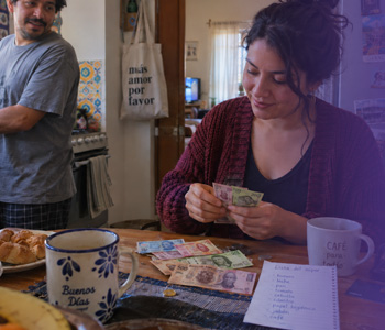 Persona comparando una compra pagada en efectivo con una compra pagada con tarjeta